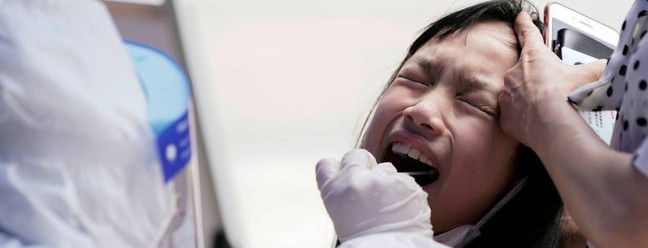 Criança reage durante o teste de ácido nucléico em Wuhan, a cidade chinesa mais atingida pelo surto da COVID-19, província de Hubei, China — Foto: ALY SONG / REUTERS
