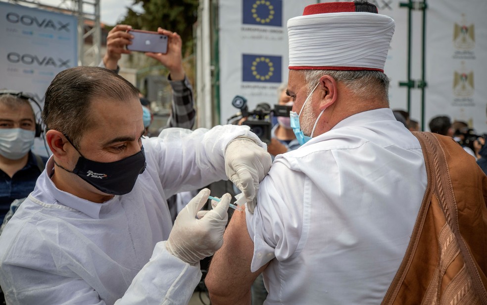Clérigo muçulmano palestino recebe dose de vacina contra Covid-19 da Pfizer em Ramallah, em foto de 21 de março — Foto: AP Photo/Nasser Nasser