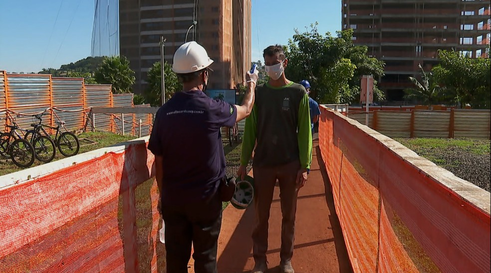 Trabalhadores da construção civil passam por medição de temperatura antes de entrar em obra de Ribeirão Preto — Foto: Ronaldo Gomes/EPTV