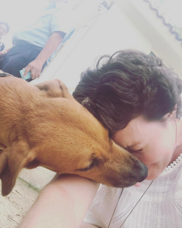 A atriz Shannen Doherty brincando com um cachorro (Foto: Instagram)