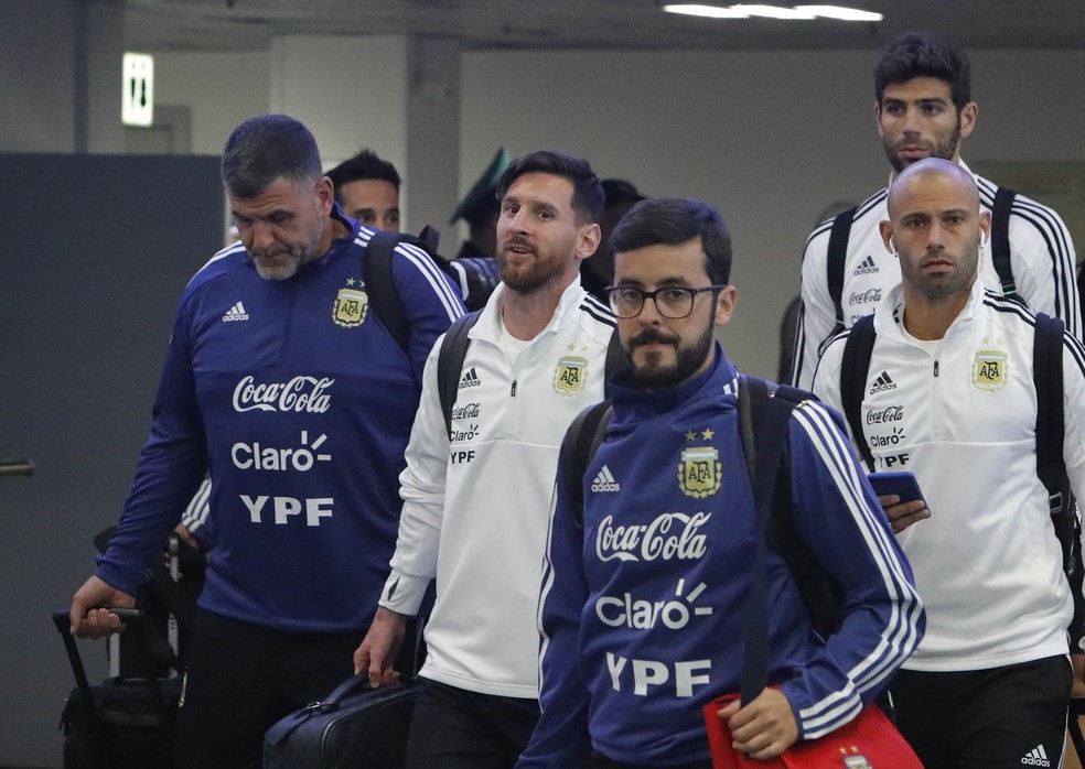  Lionel Messi (centro) e Mascherano (Ã  dir.) desembarcam (Foto: Sergei Karpukhin/Reuters)