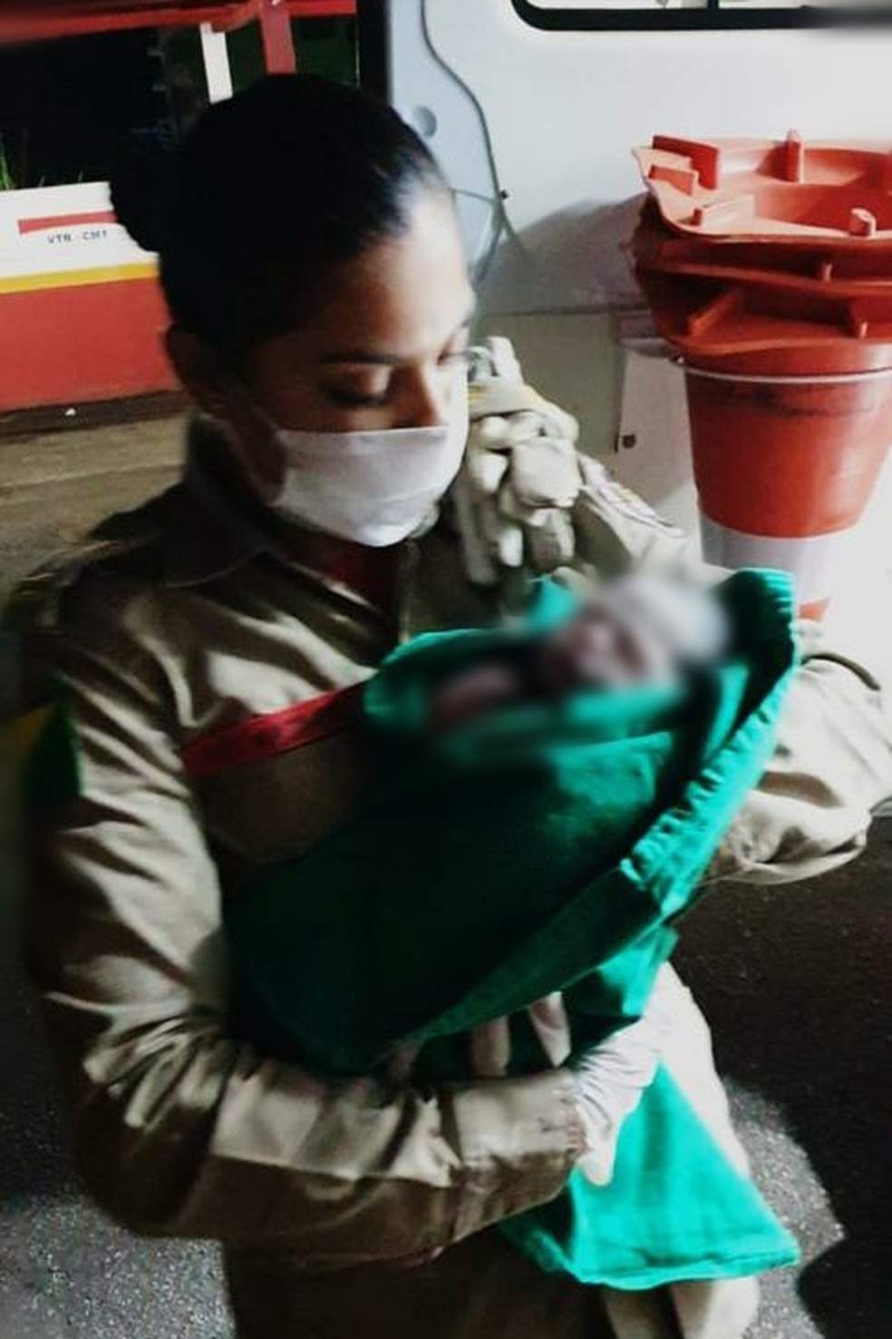 Katiuce segura a bebê após ter feito o parto da mãe  — Foto: Asscom/Bombeiros Acre 
