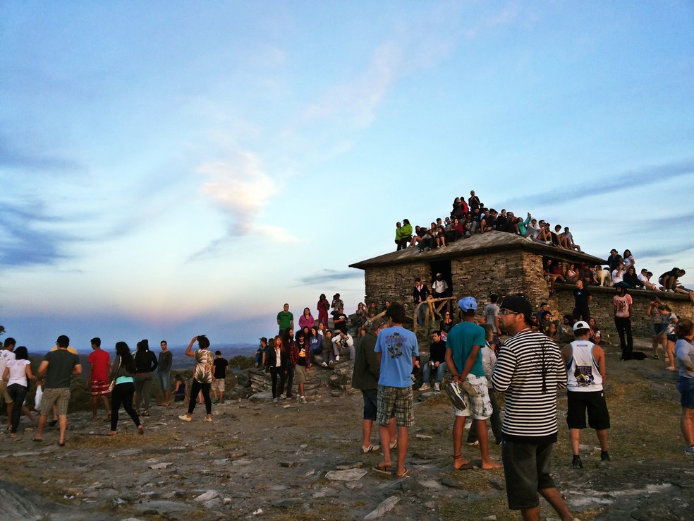 Turistas se reúnem na Casa da Pirâmide para acompanhar o anoitecer em São Tomé das Letras — Foto: Régis Melo