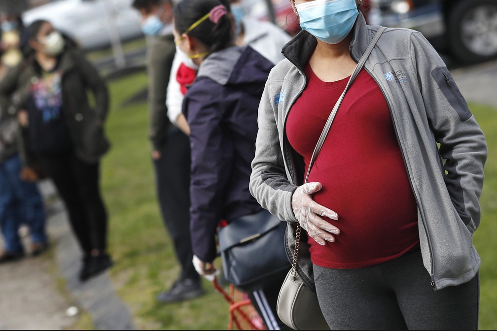 Mulher grávida é vista de máscara durante a pandemia de Covid-19 em Waltham, nos EUA — Foto: Charles Krupa/AP