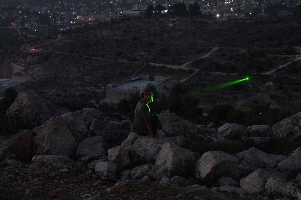 1 de jullho - Israelense é iluminado por laser de palestino perto da cidade de Nablus, na Cisjordânia  — Foto: Maya Alleruzzo/AP