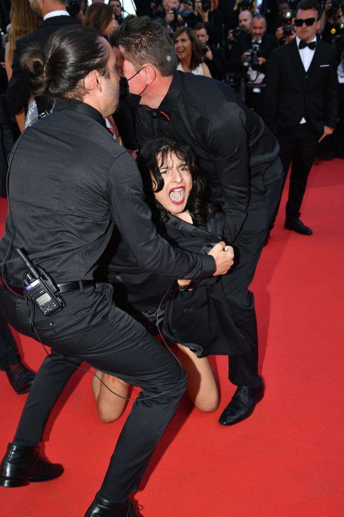 Mulher é retirada por seguranças do tapete vermelho durante o Festival de Cannes. Ela protestava nua contra a guerra na Ucrânia e a violência sexual das tropas russas (Foto: Getty )