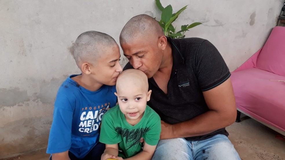 João Guilherme Dourado com o pai e o irmão de cabeça raspada — Foto: Arquivo pessoal