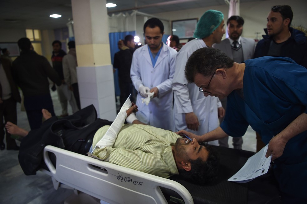 Um homem ferido recebe atendimento após explosão de um carro bomba em Cabul, nesta segunda-feira (24). — Foto: Wakil Kohsar / AFP Photo