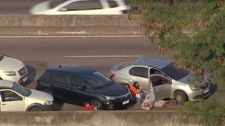 Motoristas tentam se proteger atrás de carros e muretas durante tiroteio  — Foto: Reprodução / TV Globo