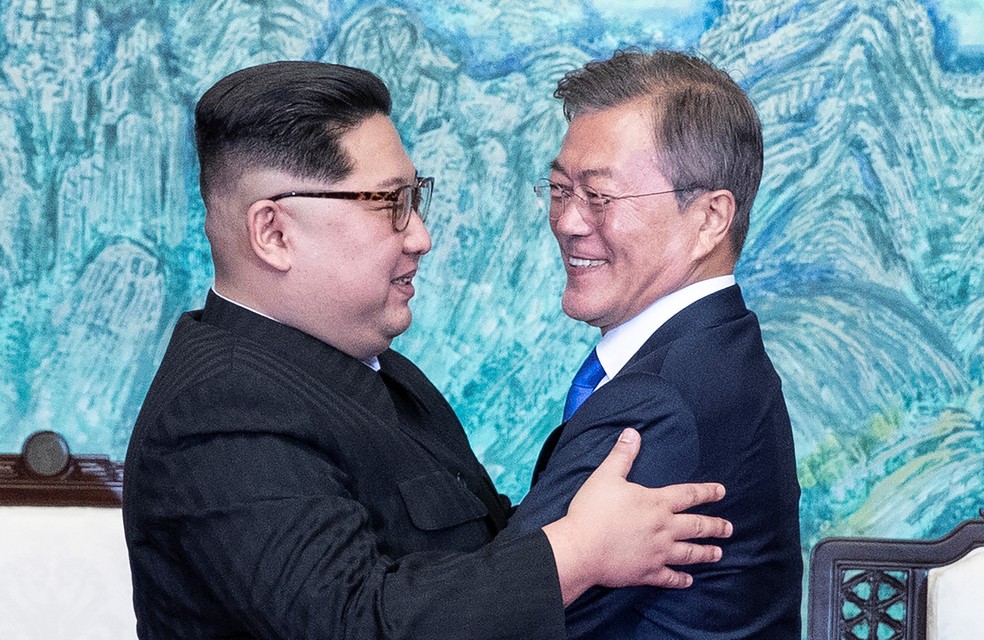 O presidente sul-coreano Moon Jae-in e o líder da Coreia do Norte Kim Jong-un se abraçam durante encontro na zona desmilitarizada que separa os dois países (Foto: Korea Summit Press Pool/via Reuters)