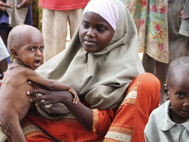 Mulher é vista cuidado de filhos desnutridos em Dadaab. Pessoas doentes não precisam jejuar durante o Ramadã, mas a maioria dos acampados que sofrem com a fome na Somália parece determinada a manter as tradições (Foto: Omar Faruk/Reuters)