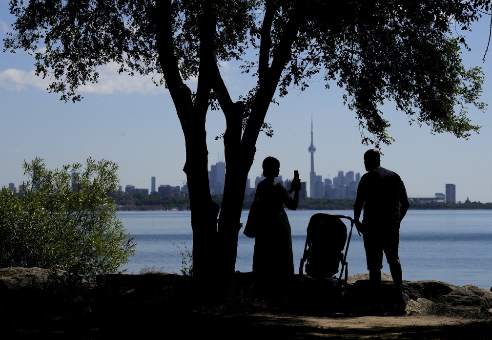 Uma família tira fotos à sombra em um dia quente em Toronto, no Canadá (23/06/22). — Foto: Nathan Denette /The Canadian Press via AP