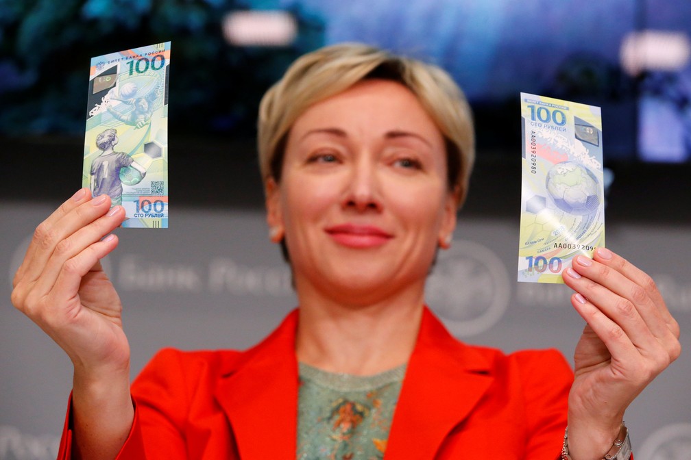 Olga Skorobogatova, presidente-adjunta do Banco Celtral da RÃºssia, mostra notas de 100 rublos feitas em homenagem Ã  Copa do Mundo de 2018 (Foto: REUTERS/Sergei Karpukhin)