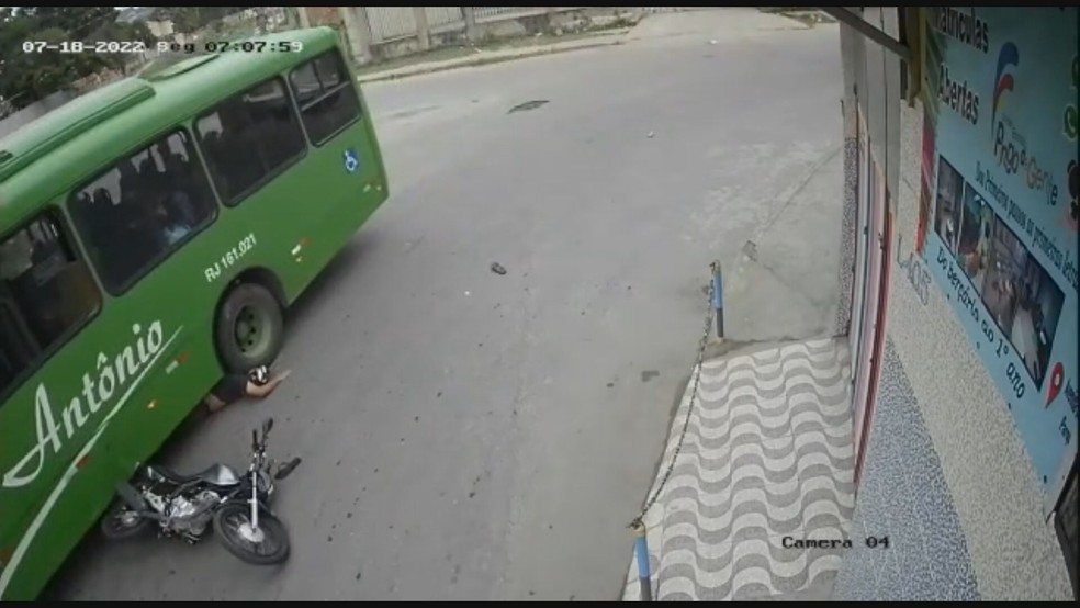 Motoqueiro cai e vai parar embaixo da roda de um ônibus no RJ — Foto: Reprodução