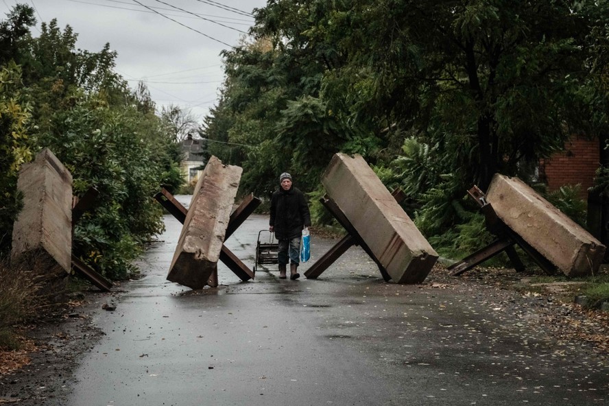 Homem caminha entre barreiras antitanque nos arredores de Bakhmut, na província ucraniana de Donetsk
