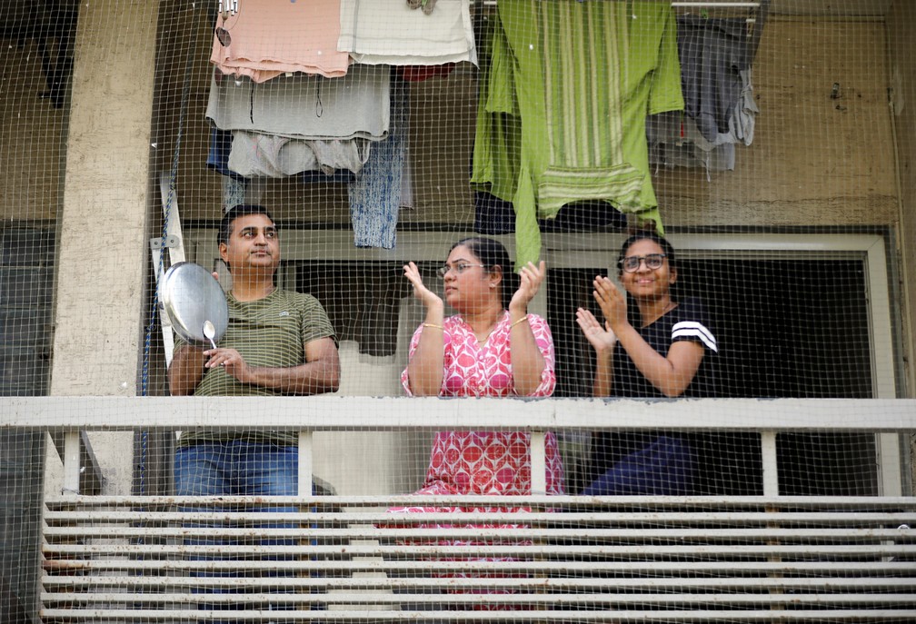 Pessoas batem palmas e panelas de suas varandas para agradecer ao pessoal de emergência e profissionais da saúde em Ahmedabad, na Índia, em 22 de março  — Foto: Amit Dave/Reuters