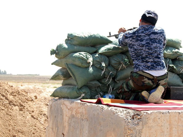 Combatente do comitê popular que apoia a campanha do governo do Iraque contra militantes jihadistas guarda posição em Taza Khurmatu, a cerca de 20 km da cidade disputada de Kirkuk, no noroeste do país (Foto: Ali Al-Bayati/AFP)