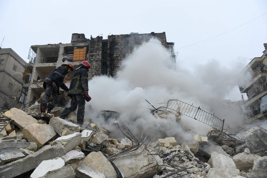 Equipes de resgate procuram sobreviventes sob os escombros de um prédio que desabou após o terremoto na cidade de Aleppo, norte da Síria