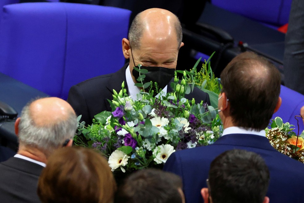 Olaf Scholz recebe flores após ser eleito chanceler da Alemanha no Parlamento, em 8 de dezembro de 2021 — Foto: Fabrizio Bensch/Reuters