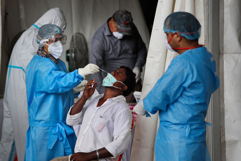 Profissionais de saúde fazem testes de Covid-19 em trabalhadores migrantes de Nova Delhi, na Índia  — Foto: Manish Swarup/AP