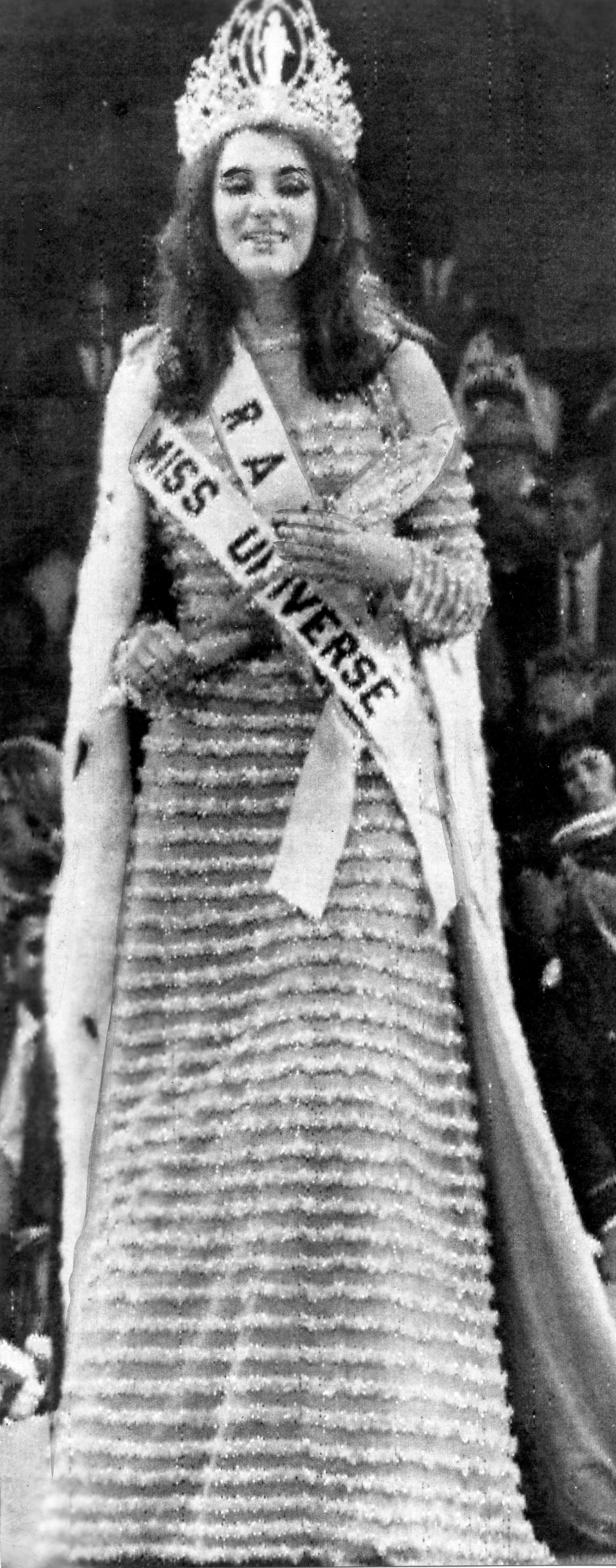 Martha desfilando com coroa, faixa, cetro e manto de Miss Universo