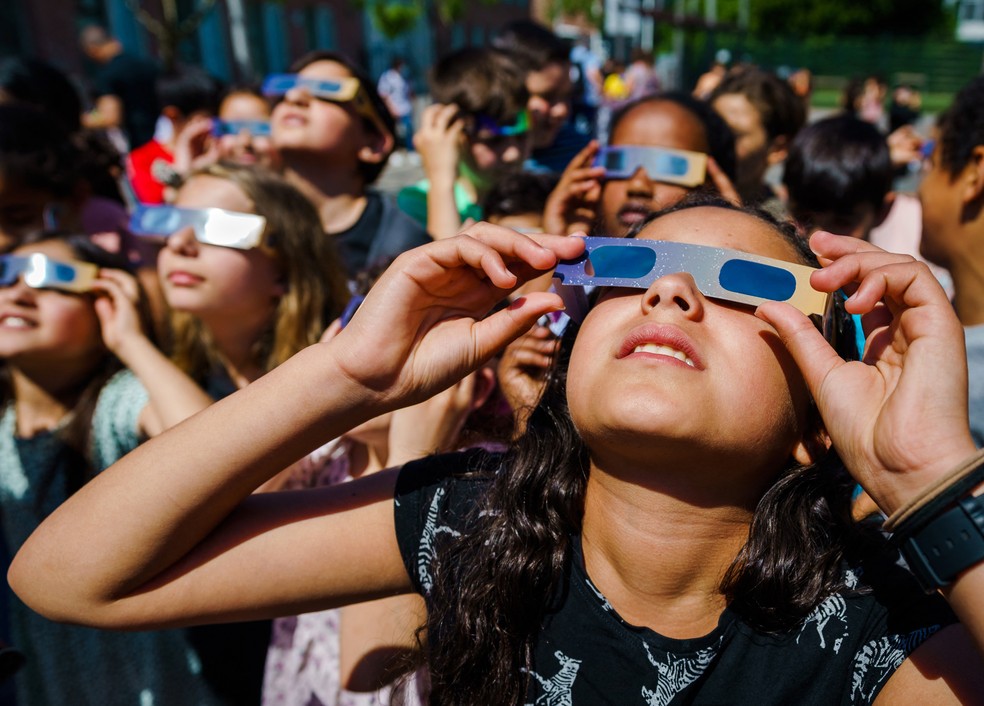 Crianças observam o eclipse solar parcial em Schiedam, na Holanda, em junho de 2021 — Foto: Marco de Swart/ANP/AFP