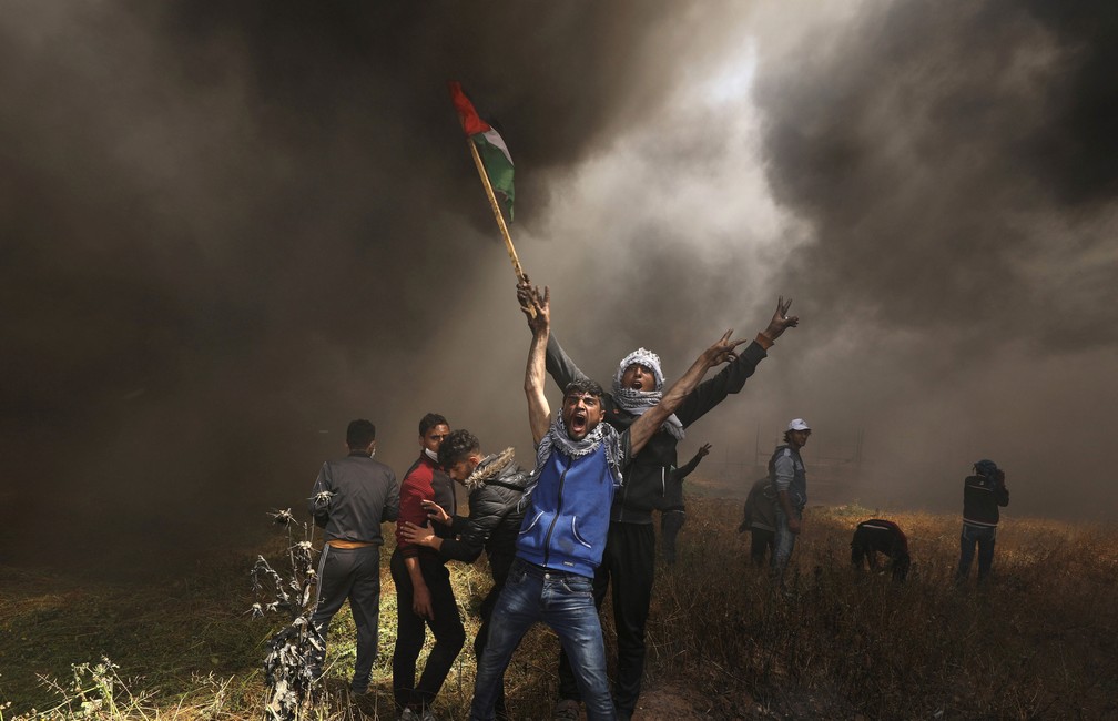 Palestinos participam de protesto na fronteira da Faixa Gaza com Israel, nesta sexta-feira (6)  (Foto: Mohammed Salem/ Reuters)
