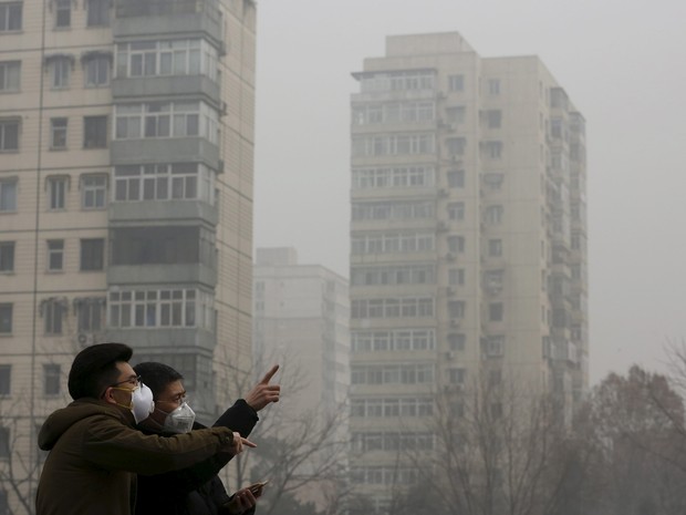 Pessoas usam mácaras contra poluição em Pequim nesta sexta-feira(25) (Foto: Kim Kyung-Hoon/Reuters)