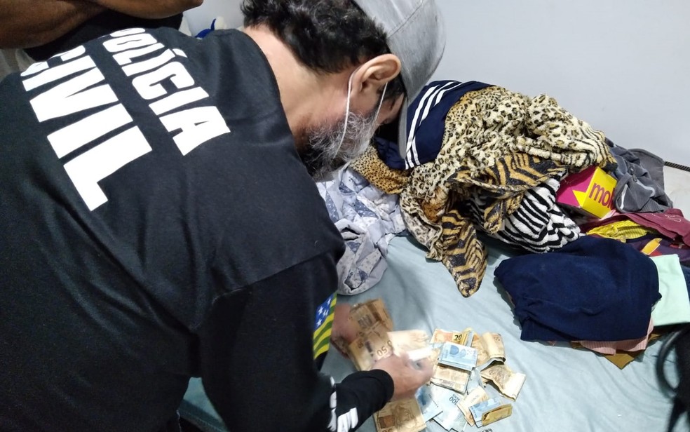 Policial apreende dinheiro em casa de suspeito de participar de torcida organizada em Goiás — Foto: Reprodução/Polícia Civil