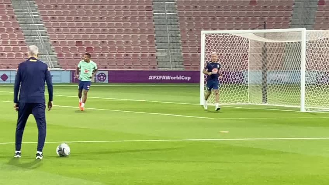 Alex Sandro corre no gramado acompanhado do preparador fsico da Seleo