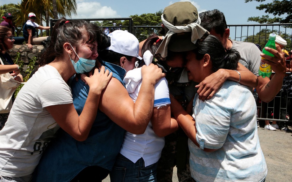 Parentes abraçam universitário livre após ficar preso durante a noite toda na Igreja Católica da Divina Misericórdia para fugir de emboscada na Universidade Autônoma Nacional da Nicarágua (Unan), em Manágua, em 14 de julho (Foto: Reuters/Oswaldo Rivas)