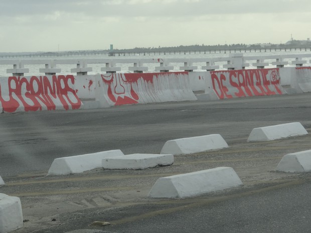 Frase ecrita em vermelho no parapeito do Riacho salgadinho chama atenção de pedestres e motoristas. (Foto: Fabiana De Mutiis/G1)