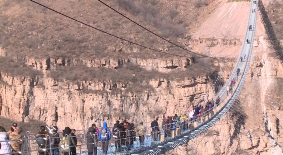 Pessoas caminham sobre ponte de vidro recém-inaugurada na China (Foto: Reuters)