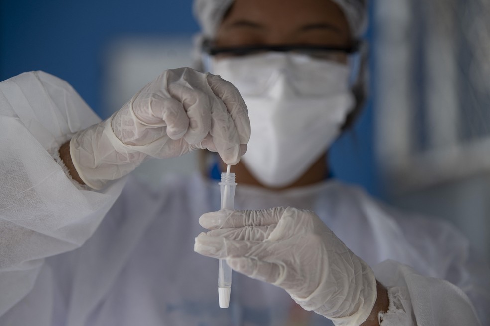 Profissional de saúde guarda amostra de teste de paciente com suspeita de Covid-19 em centro de testagem no Complexo do Alemão, no Rio de Janeiro, em 10 de dezembro. — Foto: Mauro Pimentel/AFP