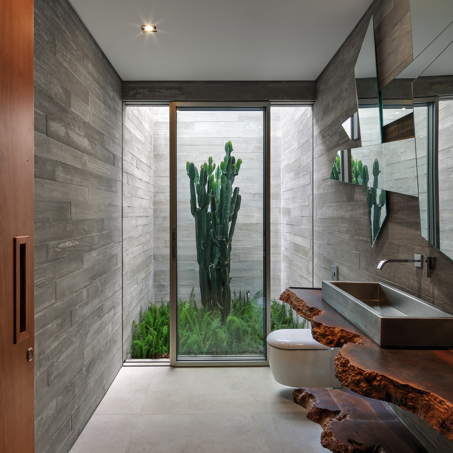 LAVABO | A integração entre os espaços internos e externos está por todo o projeto, inclusive no lavabo que possui um jardim interno (Foto: Nelson Kon / Divulgação)