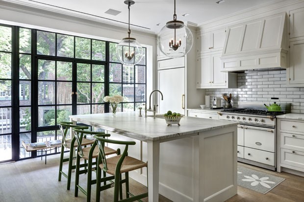 A two story extension with walls of casement windows overlooking the garden and lights by the Urban Electric Co. in the kitchen at the home of Leslie Mason, in the Greenwich Village neighborhood of New York, July 7, 2014. After several family moves throug (Foto: Bruce Buck / The New York Times)