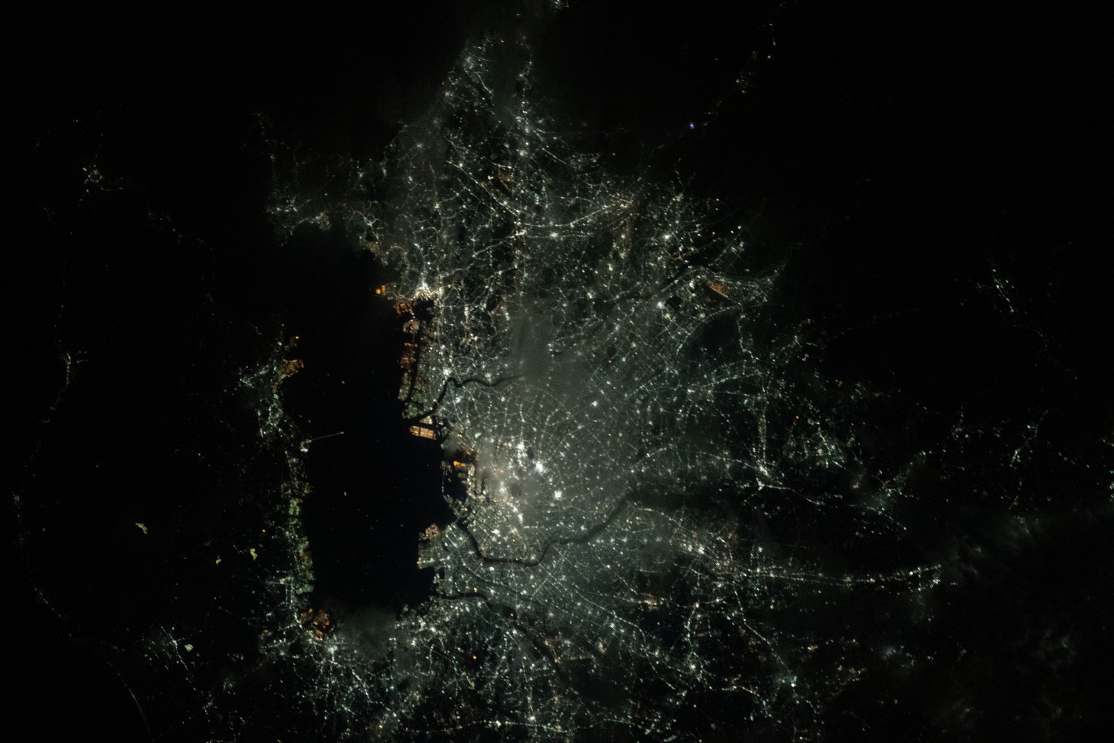 As luzes de Tóquio, Japão, e as cidades vizinhas de Kawasaki e Yokohama, na Baía de Tóquio, foram fotografadas da Estação Espacial Internacional durante uma passagem noturna orbital a cerca de 420 quilômetros acima da nação insular em 15 de março de 2020