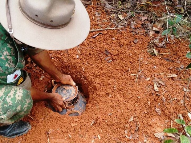 Policial desenterra recipiente com droga na zona rural de Abaeté (Foto: PM/Divulgação)