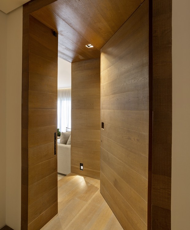 ENTRADA | O hall de entrada é uma grande caixa de madeira, de carvalho europeu tingido. O piso é da Parket e do mesmo material (Foto: Julia Ribeiro/ Divulgação)