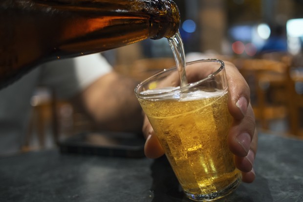 A man pours beer into a glass in a Brazilian bar. (Foto: Getty Images)