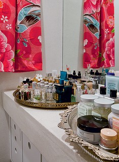 Na bancada do banheiro da estilista Adriana Barra, duas suntuosas bandejas marroquinas expõem perfumes e cremes, arrumados de forma plástica