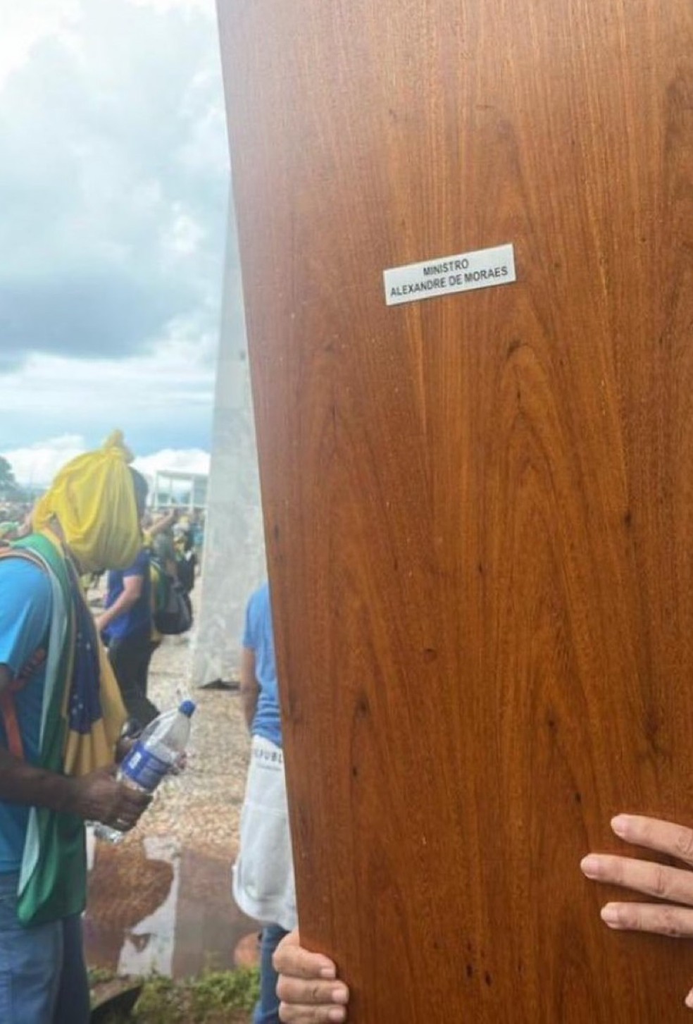 Porta do gabinete do ministro Alexandre de Moraes é carregada após ser retirada do Supremo Tribunal Federal por vândalos em Brasília — Foto: Reprodução/Redes sociais