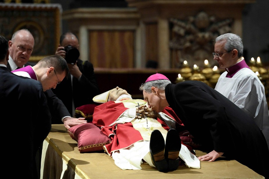 O arcebispo  Georg Gänswein beija o corpo do Papa emérito Bento XVI