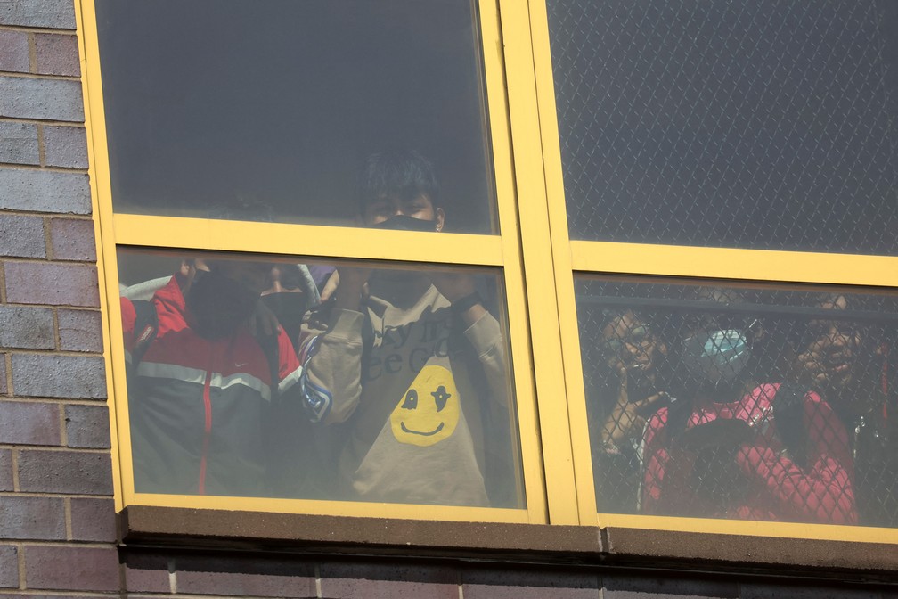 Crianças olham por uma janela no bairro do Brooklyn, em Nova York, em local onde houve um tiroteio — Foto: REUTERS/Brendan Mcdermid