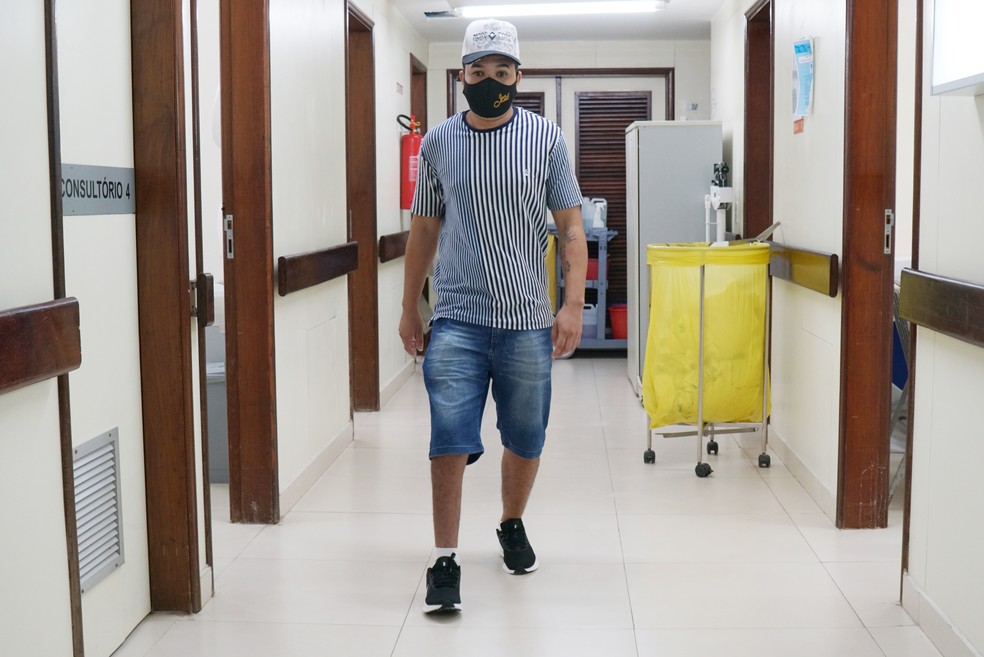 O barbeiro Iarlen Nascimento, de 22 anos, que corrigiu a deformidade no pé direito saiu do Hospital de Base calçando os tênis que ganhou — Foto: Davidyson Damasceno/Ascom IGESDF