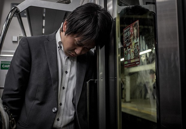Assalariado dorme no trem, na volta do trabalho, em Tóquio (Foto: Chris McGrath/Getty Images)
