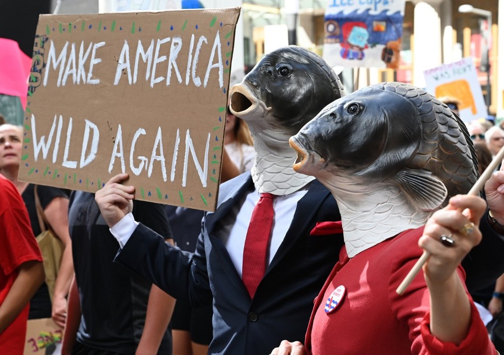 Manifestantes erguem cartaz com dizeres "Faça a América selvagem de novo", em alusão ao slogan do presidente Donald Trump, durante protesto em Nova York. — Foto: TIMOTHY A. CLARY / AFP