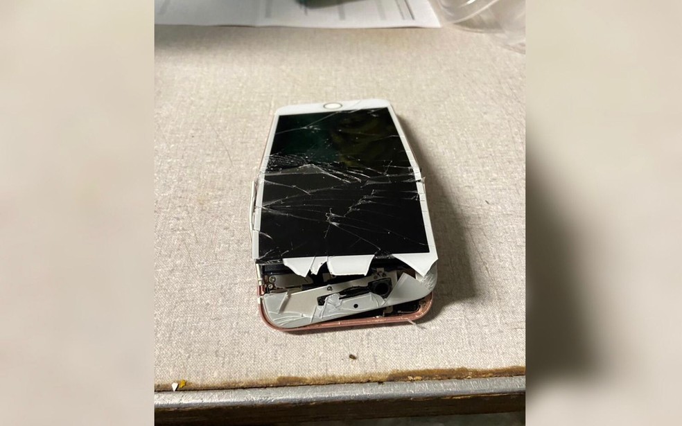 Suspeito tentou destruir aparelho celular antes de apreensão; aparelho foi apreendido em operação que apura facção liderada por policial — Foto: Divulgação