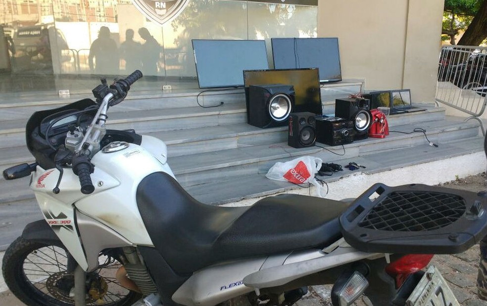 Com o foragido foram apreendidos uma moto e objetos eletrônicos roubados, além de uma arma (Foto: Divulgação/Polícia Militar)