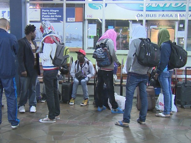 A maioria dos 12 imigrantes que desembarcaram seguirão para cidades do interiro do RS (Foto: Reprodução/RBS TV)